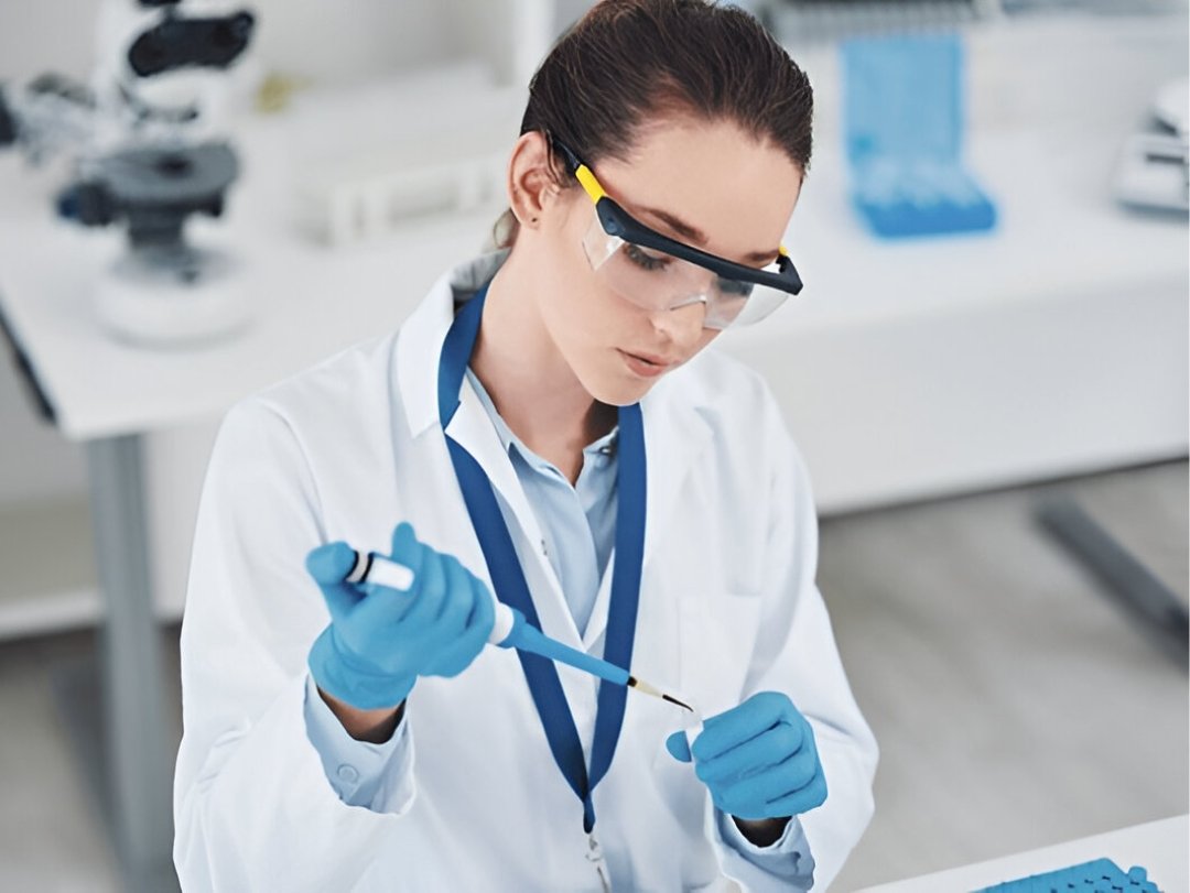 A researcher in a lab, possibly providing drug testing services, carefully uses a pipette.