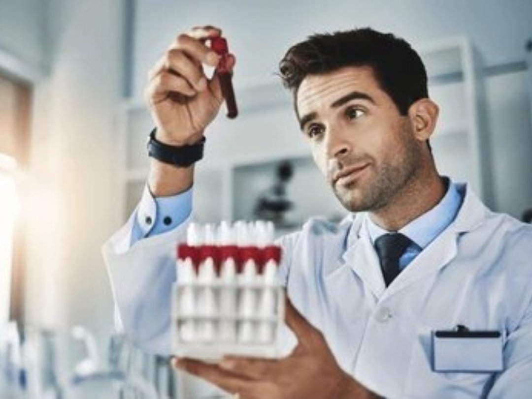 A scientist examining a blood sample in a lab, possibly for drug testing record keeping.