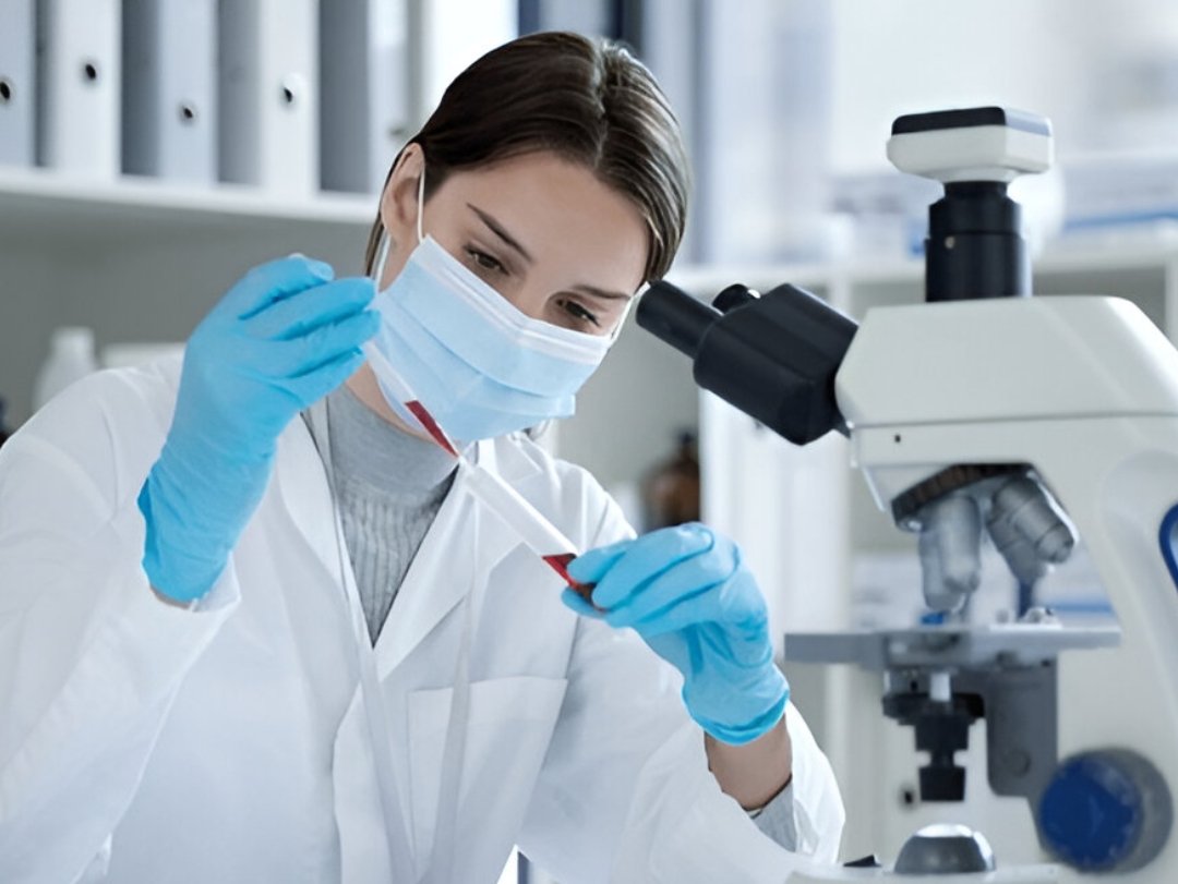  A lab technician examines a blood sample near a microscope, possibly following DOT Testing Guidelines.